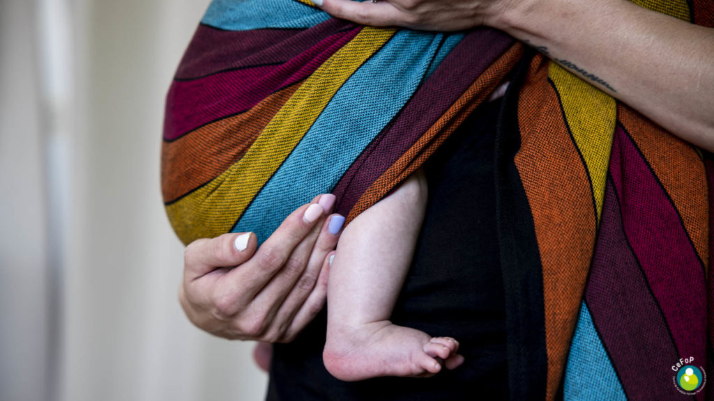 bébé installé dans un ring sling pendant un atelier de portage