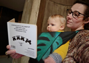 bébé porté face au monde en pleine lecture